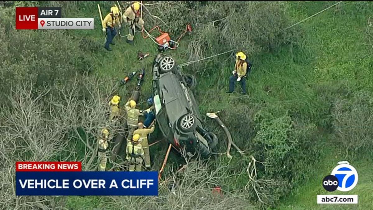 Firefighters rescue driver trapped in car after it veers off cliff in ...